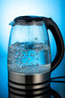 glass electric kettle with boiling water on a dark background