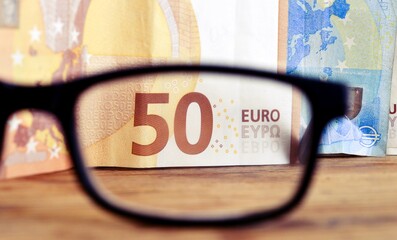 fifty euro banknote viewed trough reading eyeglasses