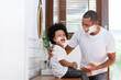 © eggeeggjiew - African American Man and little boy having fun laughing with shaving foam on their faces in bathroom at home. Funny Happy Black Father and son shaving faces in the morning