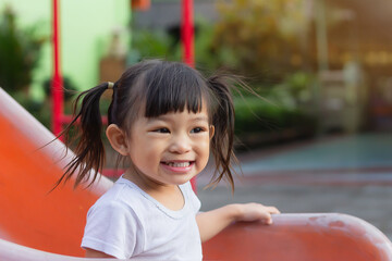 Wall Mural - Portrait image of 2-3 yeas old baby. Happy Asian child girl smiling and laughing. She playing with slider bar toy at the playground. Learning and active of kids concept.