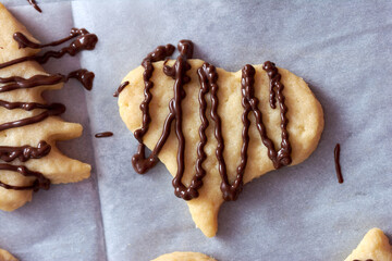 Pouring chocolate on just baked christmas cookies