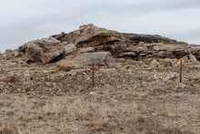 Interesting Rock Formations On Side Of Rural Road With Vintage Barbwire Fence On Overcast Day In New Mexico