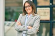 © Krakenimages.com - Young hispanic businesswoman with arms crossed smiling happy at the city
