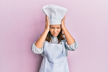 Canvas Print - Young beautiful woman wearing professional cook uniform and hat suffering from headache desperate and stressed because pain and migraine. hands on head.