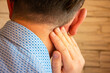 Pain behind ear in area of mastoid process concept photo. Person holds his hand over area behind ear, where pain is suspected due to otitis media, inflammation, noise in ear, hearing loss