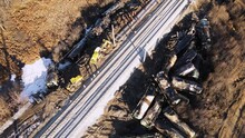 Train Wreck On The Railroad, Scattered Cisterns, Many Workers Are Walking. Aerial View Of The Accident - A Crash With Damaged Wagons Lying Next To The Rails. Rescuers Carry Out Repair Work.
