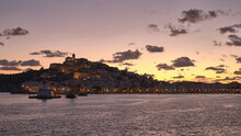 Beautiful Shot Of The Castle And Town Of Dalt Vila Across A Lake At Sunset