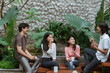 © Odua Images - four teenage chatting while sitting on table and wood bench at home garden