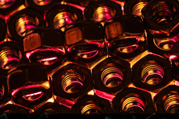 Sticker - Closeup shot of small metal screw nuts in a dark atmosphere with red and orange lights on them