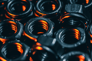 Sticker - Closeup shot of small metal screw nuts in a dark atmosphere with orange lights on it