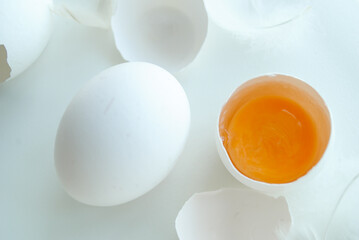 Wall Mural - Chicken eggs in a tray on a white background, broken egg, white and yolk.