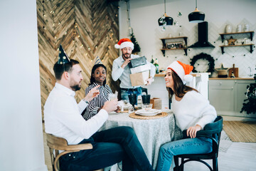 Wall Mural - Group of Christmas friends sitting at table