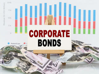 Among financial charts and money is a sign with the text - CORPORATE BONDS