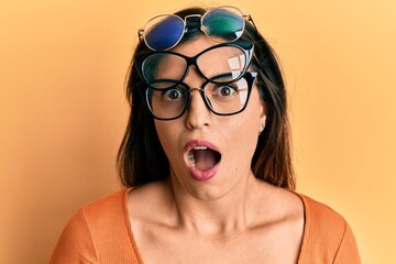 Canvas Print - Beautiful hispanic woman wearing many glass over face scared and amazed with open mouth for surprise, disbelief face