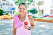 © Krakenimages.com - Middle age sportswoman asking for health care holding heart at the park