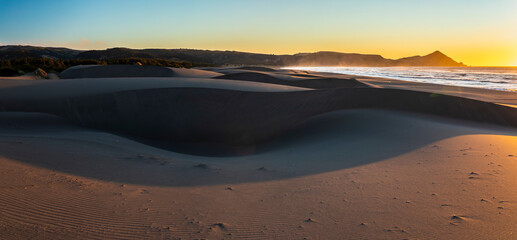 Wall Mural - an amazing sea view during sunset time of an awe sandy beach full of sand dunes till the infinite. i