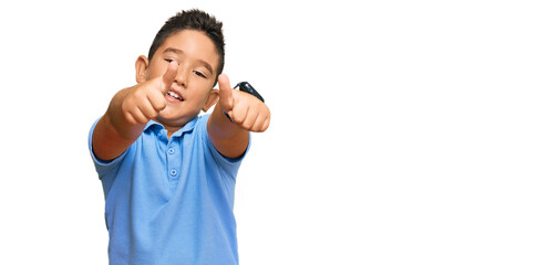 Canvas Print - Little boy hispanic kid wearing casual clothes approving doing positive gesture with hand, thumbs up smiling and happy for success. winner gesture.