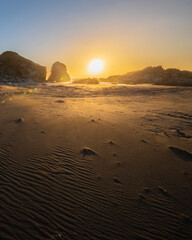 Wall Mural - an awe sunset in an idyllic beach landscape with the sunset over the water and the sunlight generati