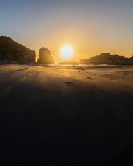 Wall Mural - an awe sunset in an idyllic beach landscape with the sunset over the water and the sunlight generati