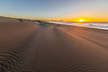 Wall Mural - an amazing sea view during sunset time of an awe sandy beach full of sand dunes till the infinite. i
