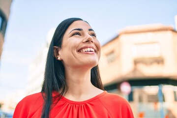 Wall Mural - Young latin girl smiling happy walking at the city.