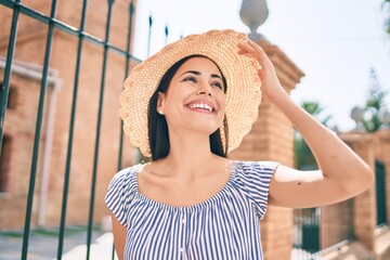 Wall Mural - Young latin tourist girl on vacation smiling happy at the city.