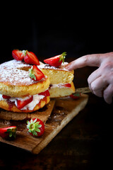 Soft focus. Victoria sponge cake. The famous dessert biscuit with strawberries.