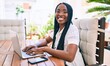 © Krakenimages.com - Young african american woman smiling happy working using laptop at terrace