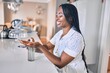 © Krakenimages.com - Young african american woman smiling happy using sanitizer hand gel at home