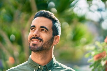 Young hispanic man smiling happy standing at the park.