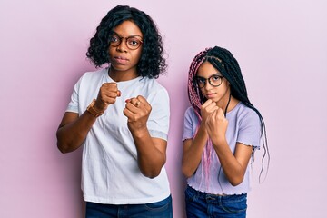 Sticker - Beautiful african american mother and daughter wearing casual clothes and glasses ready to fight with fist defense gesture, angry and upset face, afraid of problem