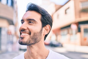 Sticker - Young hispanic man smiling happy walking at the city.