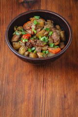 Sticker - Stewed vegetables with spices in an earthen bowl on a dark wooden background. View from above..