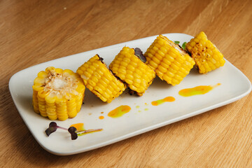 Tasty sweet grilled corn on white plate. Summer food