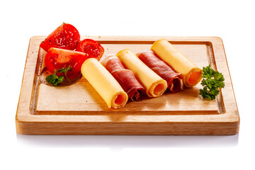 Wall Mural - Yellow cheese and smoked ham on cutting board on white background
