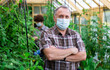 © caftor - Portrait of elderly man in protective mask in greenhouse