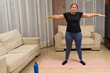 © Andres - Middle-age woman with sportswear in low shape exercising in her living room