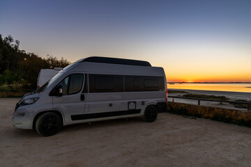 Sticker - nightfall with a colorful sky over wetlands and canals nature landscape and a camper van in the foreground