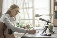 Woman Playing Guitar And Recording Her Music
