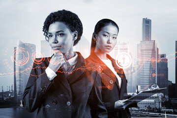 Wall Mural - Two young attractive businesswoman in suits thinking about career opportunities at cybersecurity compliance division to protect clients confidential information. IT lock icons over Singapore