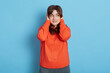 © sementsova321 - Confused girl looking away and covering ears with hands, don't want to hear, gorgeous girl isolated over blue background trying to avoid noise, wearing casual attire.