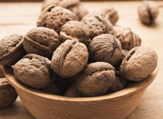 bunch of walnuts in a wooden plate on the table