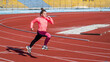teen girl running on outdoor stadium racing track, marathon