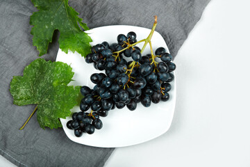 A bunch of red grapes in a white plate