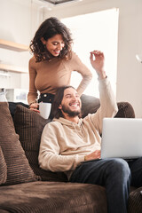 Woman laughing with her husband while bringing tea to him