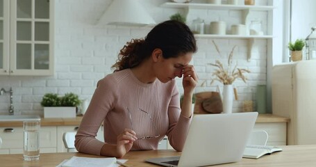 young businesswoman taking off glasses massaging nose bridge, relaxing eyes, making break while work