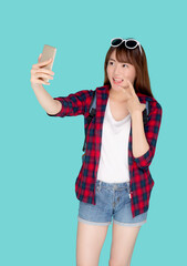 Wall Mural - Beautiful portrait young asian woman cheerful smiling and take selfie on smart mobile phone, beauty girl wear travel summer enjoy and fun in vacation isolated on blue background, holiday concept.