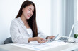 © Orathai - Asian female accountant sits at their desks and calculates financial graphs showing results about their investments, plan a successful business growth process