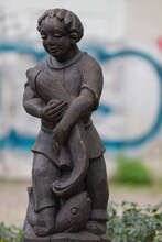Freiburg Im Breisgau, Germany - 11 01 2012: Wooden Statue Of A Boy With A Fish In The Park Outdoors