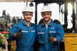 © Thirawatana - Engineer or technician Concept. Two Males mechanic with a blue uniform showing thumb up in factory.